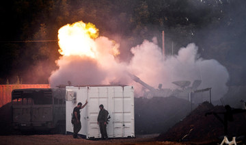 Israeli soldiers stand by, as a mobile artillery unit fires on the Israeli side of the Israel-Lebanon border December 2, 2023. 