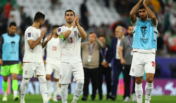 Iran’s Ehsan Hajsafi and Shahriar Moghanlou celebrate after the match. (Reuters)