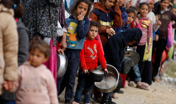 Palestinians stand in a line as they wait to receive food amid shortages of food supplies in Rafah in the southern Gaza Strip.