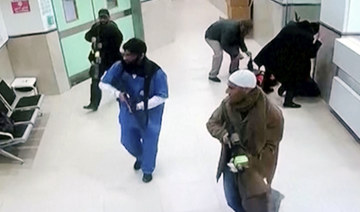 Israeli forces disguised as civilians and medical workers hold weapons in a hallway at the Ibn Sina Hospital in the West Bank.