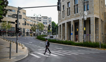 A man crosses an empty street in Jerusalem on April 14, 2024. (AFP)