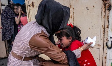 A woman consoles a shocked child reacting after Israeli bombardment in Nuseirat in the central Gaza Strip on April 29, 2024. 