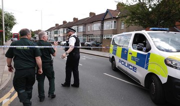 A police officer speaks to ambulance staff at a crime scene in Hainault, east of London on April 30, 2024.