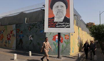 A person walks past a banner with a picture of the late Iran’s President Ebrahim Raisi on a street in Tehran, Iran May 20, 2024.