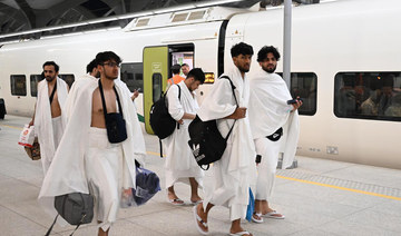 Umrah pilgrims wearing ihram walk at a Haramain High Speed Railway station. (SPA)