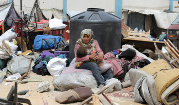 A woman sits with a child in Rafah, in the southern Gaza Strip, May 28, 2024. (Reuters)