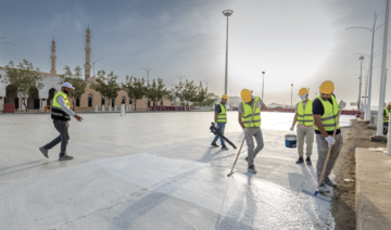 Workers apply the “cool pavements” material to the area around the Namirah Mosque in Arafat. (@RGAsaudi)