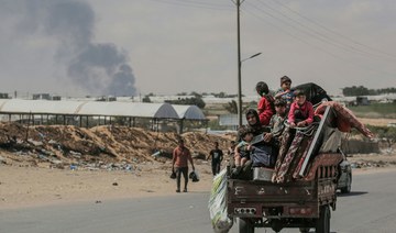 Palestinians fleeing with their belongings ride atop their vehicle in Rafah in the southern Gaza Strip on May 29, 2024. (AFP)