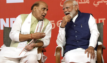 PM Narendra Modi, right, chats with Defense Minister Rajnath Singh before addressing supporters at the BJP headquarters.