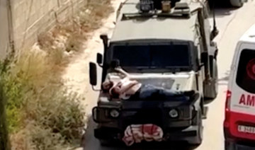 Israeli forces strap wounded Palestinian to jeep during raid
