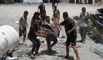 Palestinians carry a casualty outside the headquarters of UNRWA following an Israeli strike, amid the Israel-Hamas conflict.