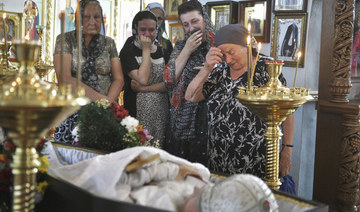 Women stand at the coffin of Orthodox priest Father Nikolay Kotelnikov, who was killed by armed militants.