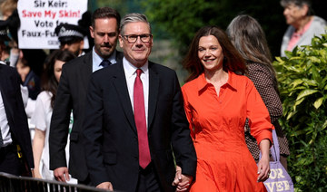 Britain’s opposition Labour Party leader Keir Starmer and his wife Victoria Starmer walk outside a polling station.