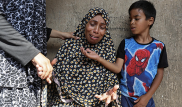 A Palestinian woman reacts next to a child after an Israeli air strike on a UN school sheltering displaced people.