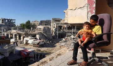 Palestinian children sit on the balcony of their house which was heavily damaged by Israeli bombardment.