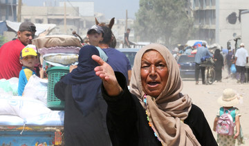 Palestinian woman gestures as others flee the eastern part of Khan Younis after they were ordered by Israeli army to evacuate.