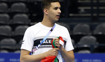 Yazan Al Bawwab of Palestine, with a Palestine flag before training. REUTERS