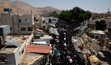 Mourners carry coffins, during the funeral of children who were killed at a soccer pitch by a rocket fired from Lebanon.