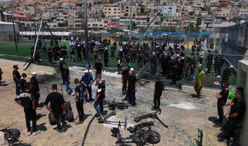 Members of the Druze community look at the damaged fence at a football pitch on July 28, 2024 in the Druze town of Majdal Shams 