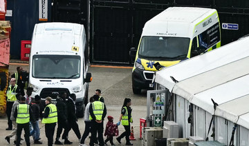 Migrants picked up at sea attempting to cross the English Channel from France are escorted ashore at the marina in Dover.