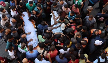 Mourners surround bodies of Al Jazeera Arabic journalist Ismail Al-Ghoul and cameraman Rami Al-Refee, killed in Israeli strike.
