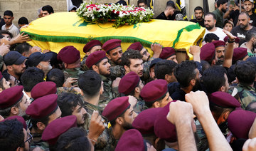 Hezbollah fighters carry the coffin of their top commander Fuad Shuku during his funeral procession in Beirut. 