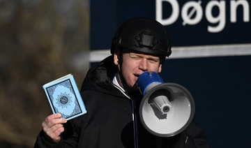 Far-right politician Rasmus Paludan holds up a copy of the Qur’an as he speaks in front of a mosque in Copenhagen. (File/AFP)