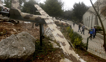 People pass by a replica drone in a war museum operated by Hezbollah in Mlita village, southern Lebanon, on Feb. 19, 2022. (AP)