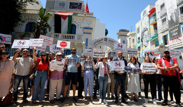 Tunisian journalists carry placards and shout slogans during a demonstration in Tunis on May 27, 2024. (AFP)