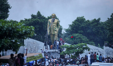 Anti-government protesters try to topple a statue of Sheikh Mujibur Rahman, Bangladesh’s founding father, in Dhaka on August 5.