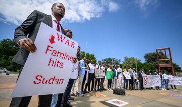 A man holds a placard during a demonstration on the opening day of Sudan ceasefire talks, in Geneva, on August 14, 2024. (AFP)