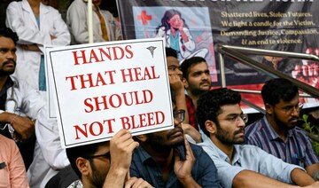 Doctors hold posters as they strike to protest the rape and murder of a young medic from Kolkata, at the Gandhi Hospital.