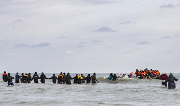 Migrants board a smuggler’s boat in an attempt to cross the English Channel, on the beach of Gravelines, near Dunkirk.