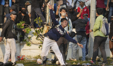 A protester throws a rock toward riot police during a rally against controversial changes to election laws.