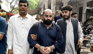 FIA personnel escort Farhan Asif (C), arrested allegedly over cyber terrorism, to a court in Lahore.