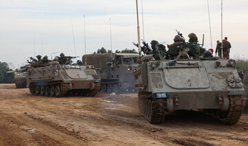 Israeli troops prepare weapons and military vehicles by the border fence before entering the Gaza Strip. (File/AFP)