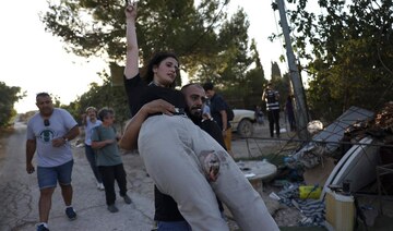 An injured activist bitten by a settler’s dog is evacuated as activists confront settlers in Al-Makhrour in occupied West Bank