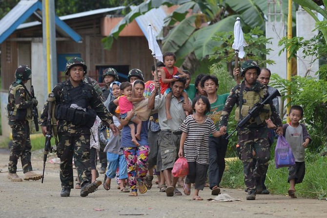 Philippines says militants keep up week-long fight with prisoners, looted guns