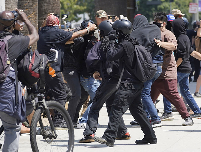 Anti-vaccination demonstrators left, clash with counter-protesters during an anti-vaccination protest in front of the City Hall in Los Angeles on Saturday, Aug. 14, 2021. (AP)