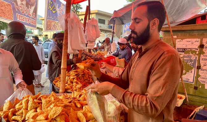 Pakistani shoppers purchase vegetables from a stall inside a