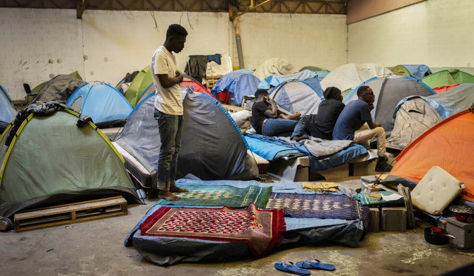 A migrant prays at an abandoned warehouse turned migrant camp in Calais, northern France, on Wednesday, May 15, 2024. (AP)