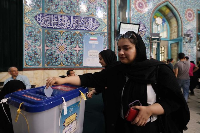 An Iranian woman casts her ballot at a polling station in Tehran during Iran’s presidential election on June 28, 2024, following the death of ultraconservative president Ebrahim Raisi in a helicopter crash last month. Iranians voted on June 28 in a presidential election marked by a lone reformist’s bid to break through against a divided conservative field. (AFP)