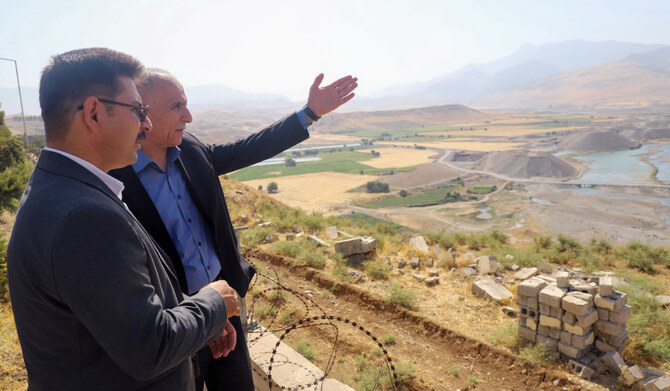 Iraqi officials check the dried-up riverbed around the 