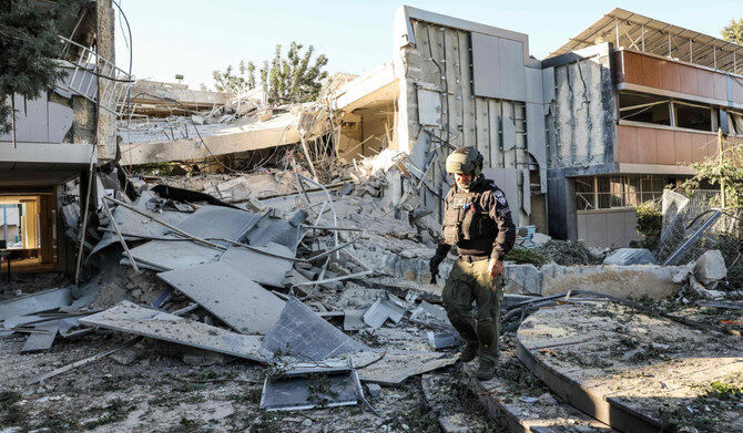 A member of a Bomb Disposal Unit inspects the rubble of a destroyed school building in Ramat Gan, near Tel Aviv, on December 19, 2024, after the campus was struck by debris from the reported interception of a projectile from Yemen. (AFP)