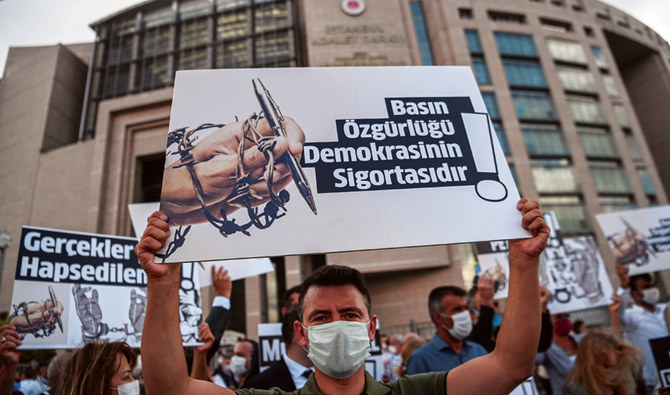 Demonstrators hold posters reading ‘Journalism is the insurance of democracy,’ in front of a courthouse in Istanbul, before a trial of jailed journalists. (AFP)