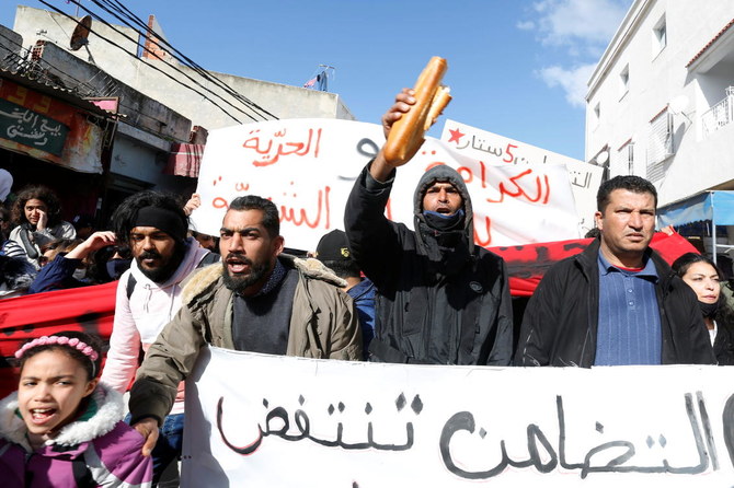 Demonstrators carry signs during an anti-government protest in Tunis , Tunisia January 26, 2021. (Reuters)