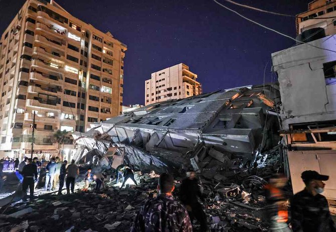 People gather at the site of a collapsed building in the aftermath of Israeli air strikes on Gaza City on May 11, 2021. (AFP)