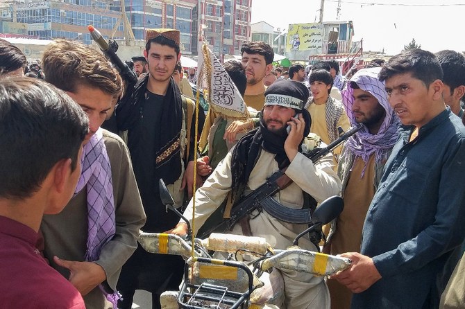 Taliban fighter (C) is seen surrounded by locals at Pul-e-Khumri on August 11, 2021 after Taliban captured Pul-e-Khumri. (AFP)