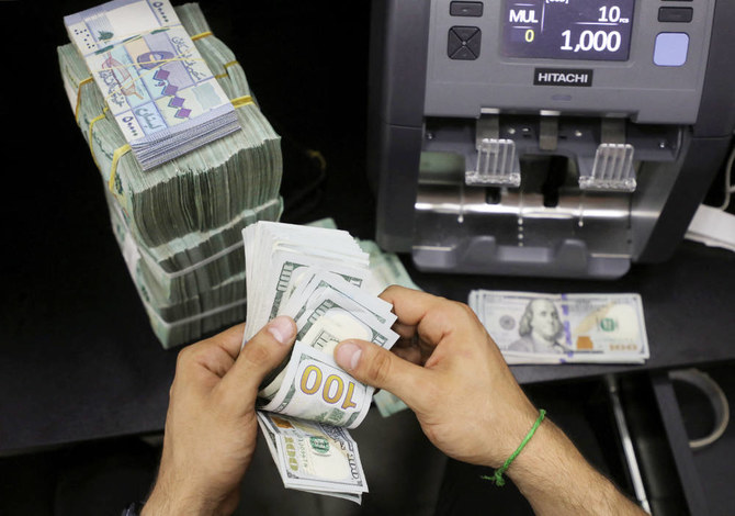 A money exchange vendor counts U.S. dollar banknotes next to Lebanese pounds at a currency exchange shop in Beirut, Lebanon.