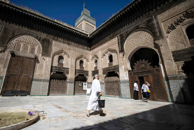 Visitors tour the Bou Inania Madrasa in the ancient Moroccan city of Fez on June 8, 2022. (AFP)